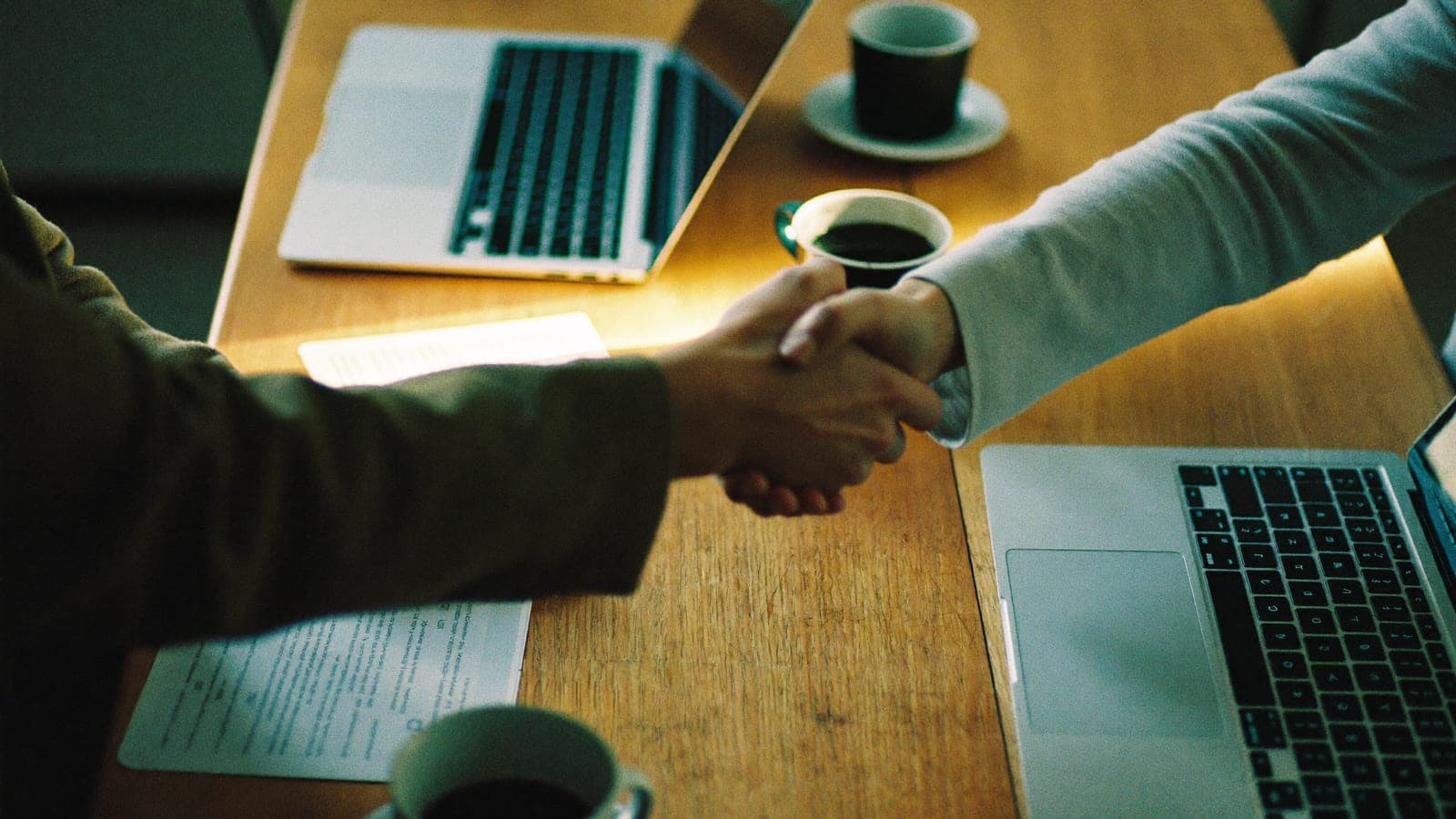 Poignée de main autour d'une table de travail, partenariat et confiance chez APPER
