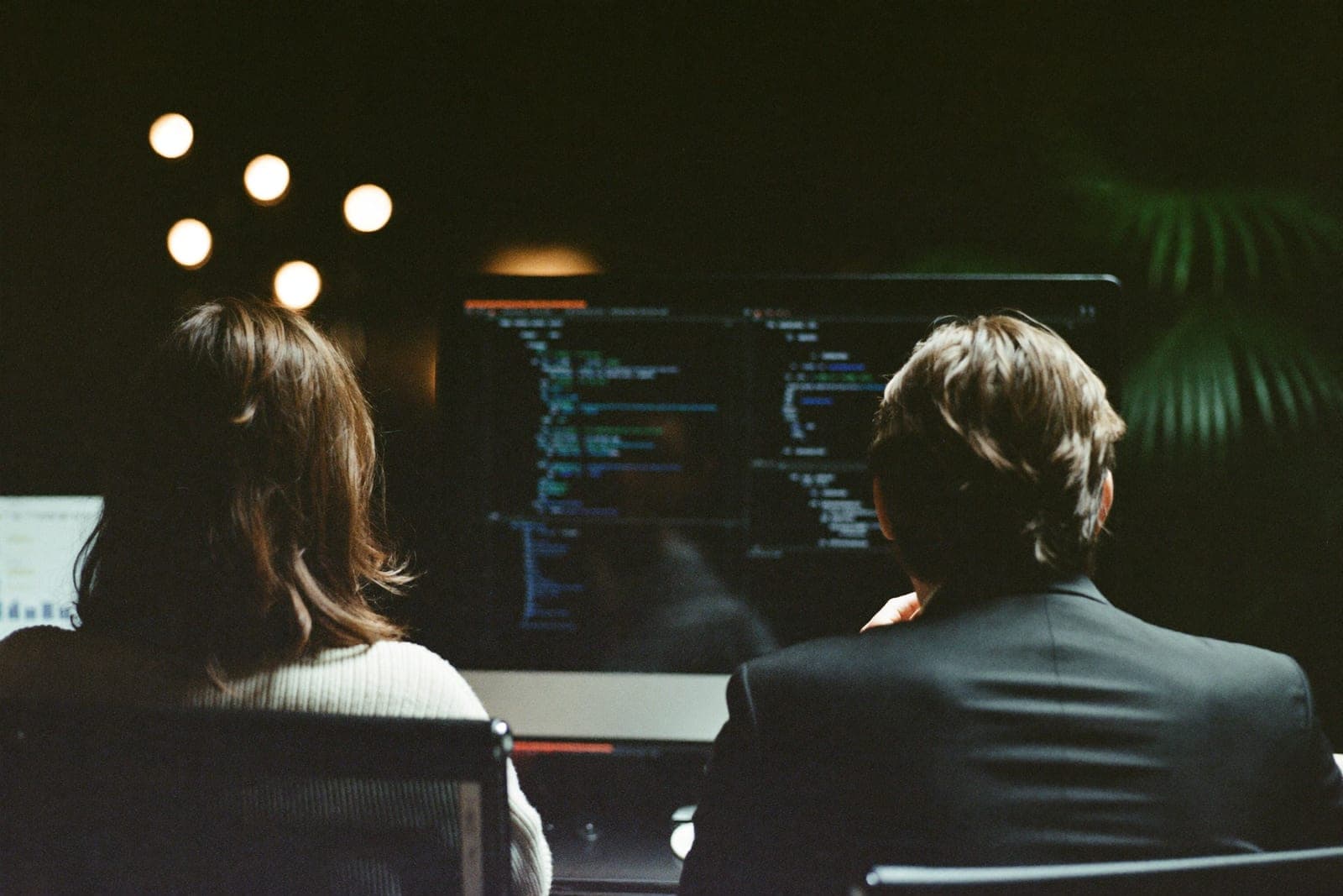 Deux collaborateurs APPER travaillant ensemble devant un écran de code